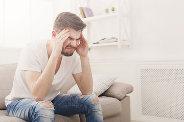 Young man having headache at home