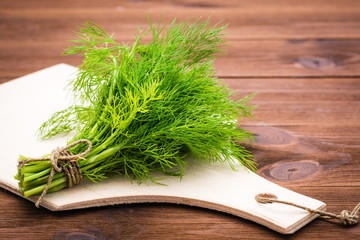 Bunch of fresh dill on a cutting board on the table
