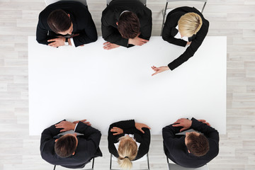 Business people sitting around empty table
