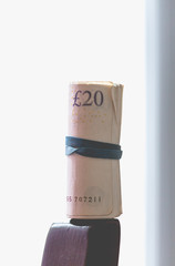 Roll of twenty pounds notes roll on bright background