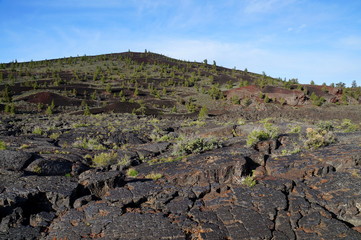 Three types of black volcanic basalt rock: cinder cone, formed by small porous pebbles, relatively smooth pahoehoe lava, aa lava chunks of relatively angular pieces of lava. Craters of the Moon.