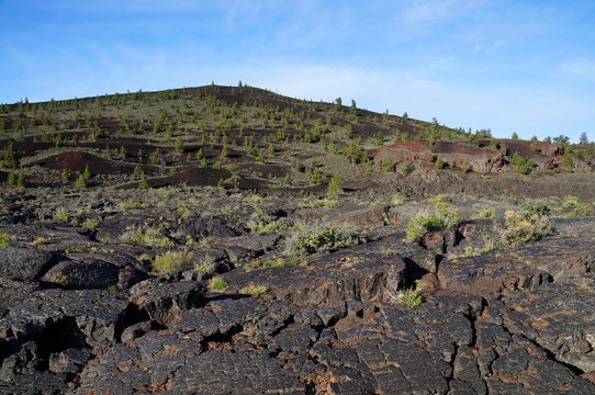 Three types of black volcanic basalt rock: cinder cone, formed by small porous pebbles, relatively smooth pahoehoe lava, aa lava chunks of relatively angular pieces of lava. Craters of the Moon.