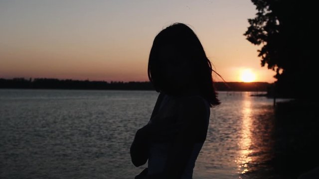 Portrait of a girl at sunset. Silhouette of a girl from the back.