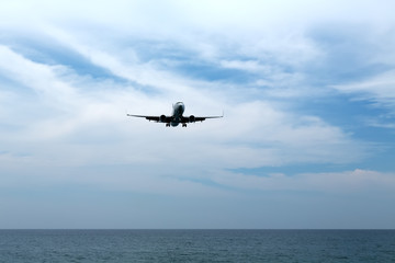 Fototapeta na wymiar Passenger plane comes in to land on the beach