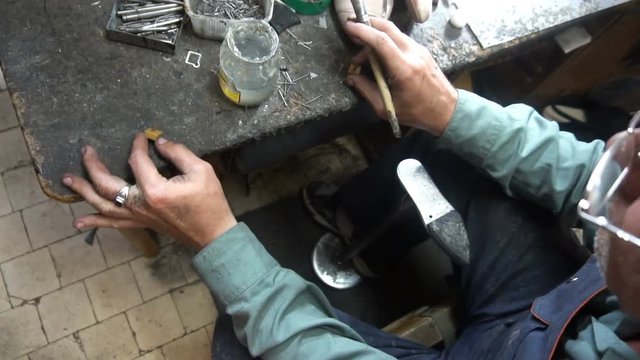 the shoemaker at work.The process of repairing shoes in workshop.