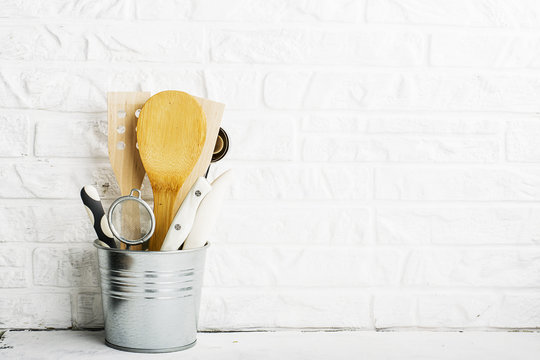 Kitchen tools, olive cutting board on a kitchen shelf against a white brick wall. selective focus