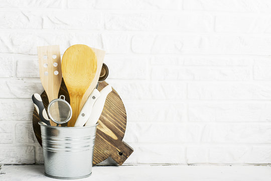 Kitchen tools, olive cutting board on a kitchen shelf against a white brick wall. selective focus