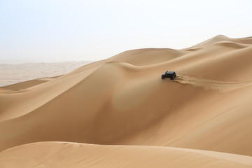 Fototapeta na wymiar car driving in Rub al Khali Desert at the Empty Quarter, in Abu Dhabi, UAE