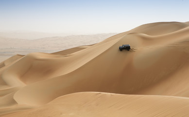 car driving in Rub al Khali Desert at the Empty Quarter, in Abu Dhabi, UAE