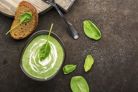 Homemade Spinach Soup Puree In A Dark Bowl On A Dark Background With Grain Bread. Top View.