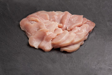 Fresh turkey leg fillets over black slate