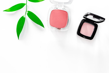 Eyeshadow and blush on white table background top view copyspace