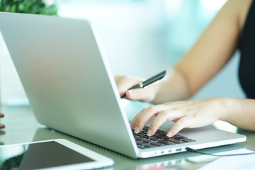 close up work secretary woman working by typing on laptop computer in office room.