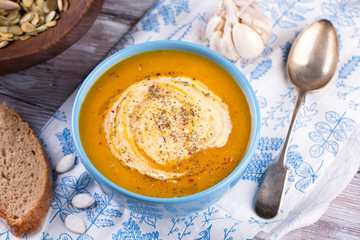 Roasted pumpkin and carrot soup with cream and pumpkin seeds