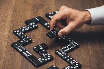 Businessman playing with dominoes