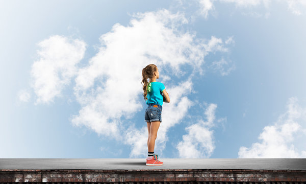 Concept of careless happy childhood with girl looking far away