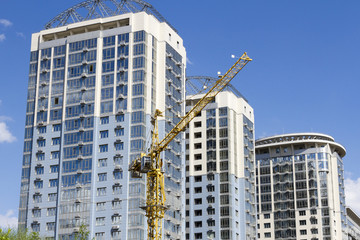 Tower crane against the background of three new high-rise buildings