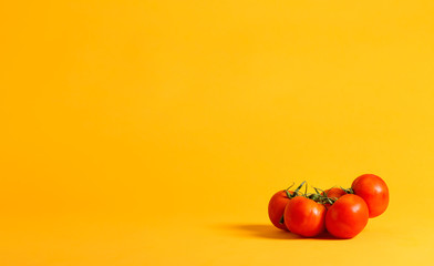 Group of whole red tomatos on a yellow background