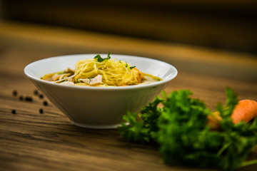 Chicken soup with noodles and fresh vegetables in bowl