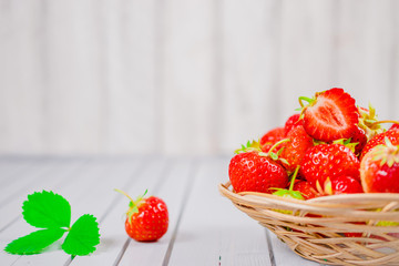 strawberries in bowl on wooden background with copy space and low key.