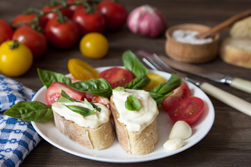 Italian Bruschetta with cheese, basil and tomatoes. Cooking.