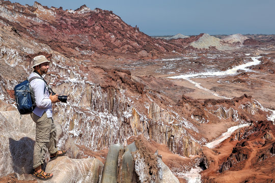 Photographer traveler on foot hiking up the salt mountains, Iran.