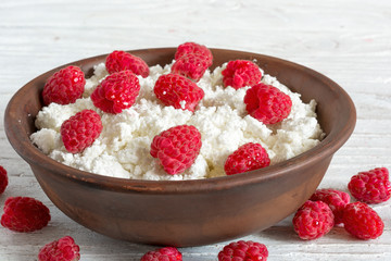 bowl of cottage cheese with fresh ripe raspberry for healthy breakfast