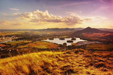 View to Zernosecke jezero lake and Lovos hill from Radobyl hill  in CHKO Ceske Stredohori tourist area at sunset  in czech summer landscape