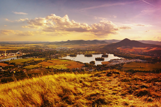 View to Zernosecke jezero lake and Lovos hill from Radobyl hill  in CHKO Ceske Stredohori tourist area at sunset  in czech summer landscape