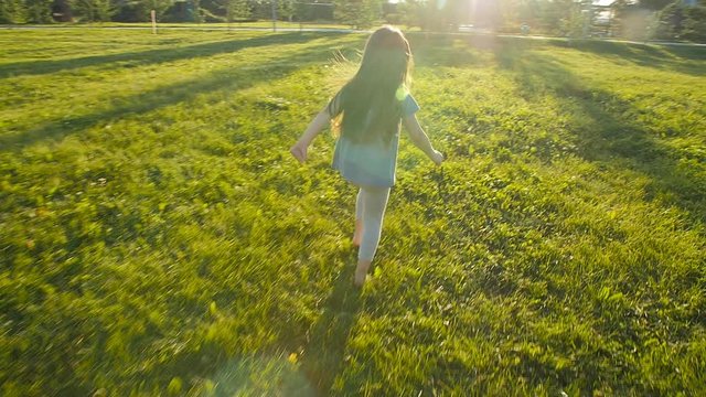 Running little happy girl green meadow in slow motion