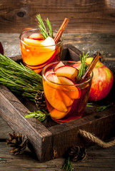 Christmas, Thanksgiving drinks. Autumn, winter cocktail grog, hot sangria, mulled wine - apple, rosemary, cinnamon, anise. On old rustic wooden table, tray. With cones, rosemary branches. Copy space