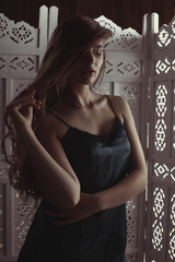 Obraz premium Young blonde woman with long lush hair in the dark studio