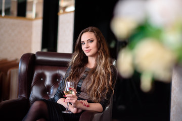 A beautiful girl is drinking champagne in a restaurant.