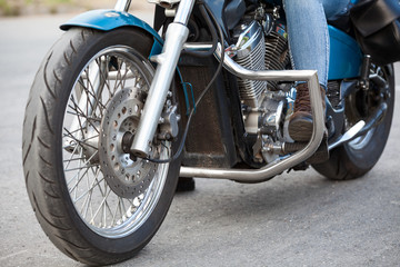 Obraz premium Close-up, front view at motorcyclist foot with protective brown boot on the stands of motorbike with chrome protective arcs