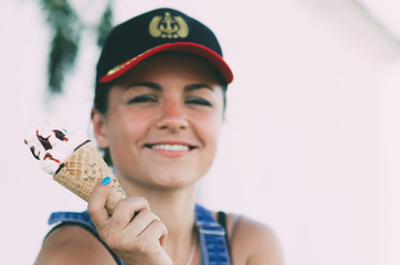 Girl in denim overalls with ice cream in hand