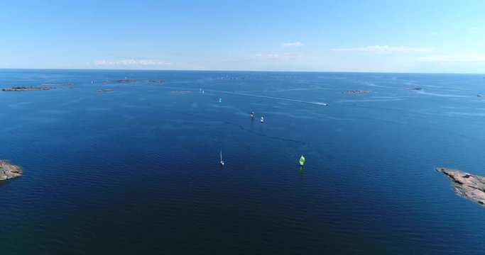 Yachts on baltic sea, Cinema 4k aerial view above the baltic sea and towards a group of colorful sailboats, out on the turquoise sea, on hango regatta day, in the finnish archipelago of Hanko, Finland
