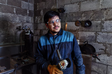 Worker with angle grinder pose in a garage for handwork