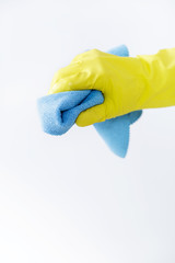 hand in rubber yellow glove holding sponge on white background. cleaning