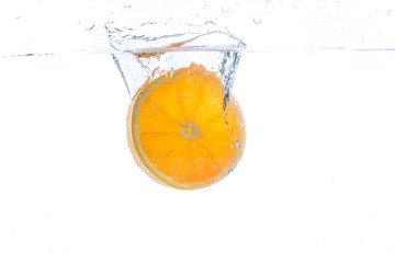 Fototapeta na wymiar orange slice in water splash on white background