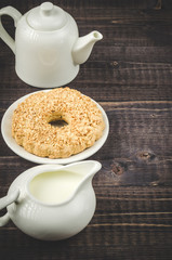 pastries and white creamer with a teapot/pastries and white creamer with a teapot on a wooden background