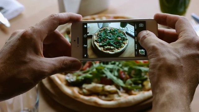 take a photo of pizza with mobile phone camera for social network