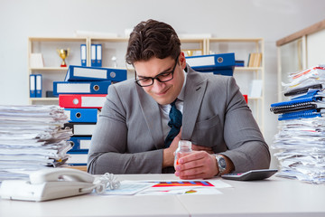 Businessman taking pills to cope with stress