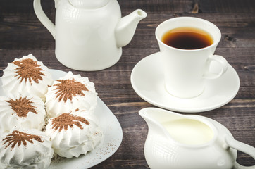 creamer, cup of coffee and marshmallows/creamer, cup of coffee, teapot and dessert