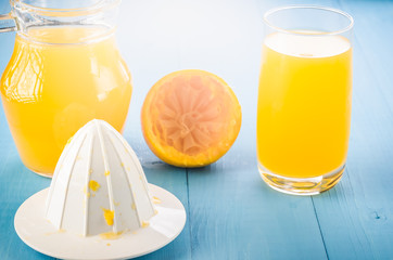 extractor and fresh orange juice in a glass/extractor and fresh orange juice in a glass on a wooden...