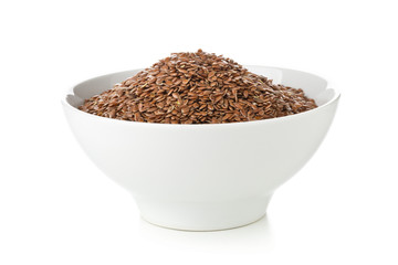 Uncooked, raw linseed or flax seed in white bowl over white background