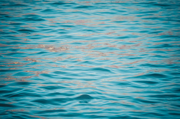 Blurry sparkle sunlight reflections on the shiny water rippled abstraction. Liquid vibrant texture pattern, bright sunny background
