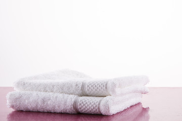 Obraz na płótnie Canvas Spa. Two white towels on a pink marble table. White background.