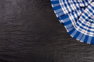 blue checkered tablecloth on the black stone table with copy space for your text. Top view