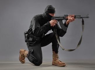 Close-up of man shooting with machine gun isolated