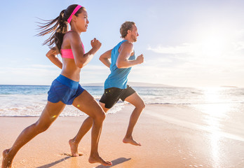 Healthy active runners couple running on beach working out cardio together. Fitness sports lifestyle. - Powered by Adobe